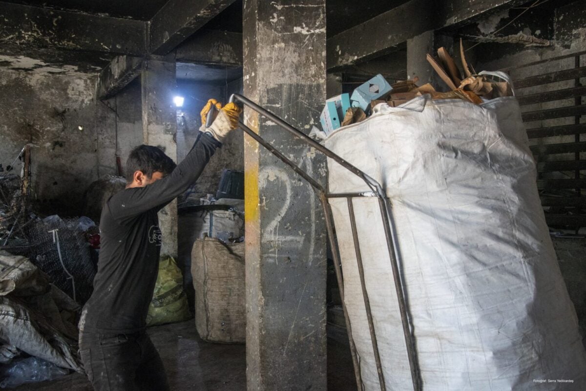 Halef Ay ağırlığı 100 kiloyu geçen geri dönüşüm atıklarını ayrıştırılmak üzere depoya yerleştirirken. (Fotoğraf: Serra Yedikardeş)